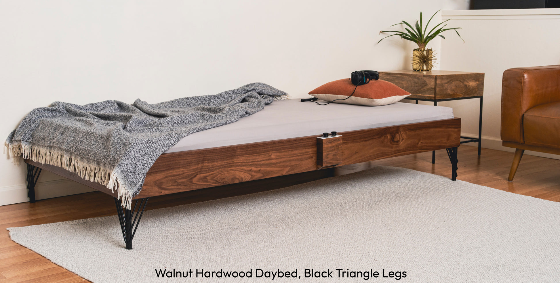 A walnut hardwood Crescendo Daybed in a living room