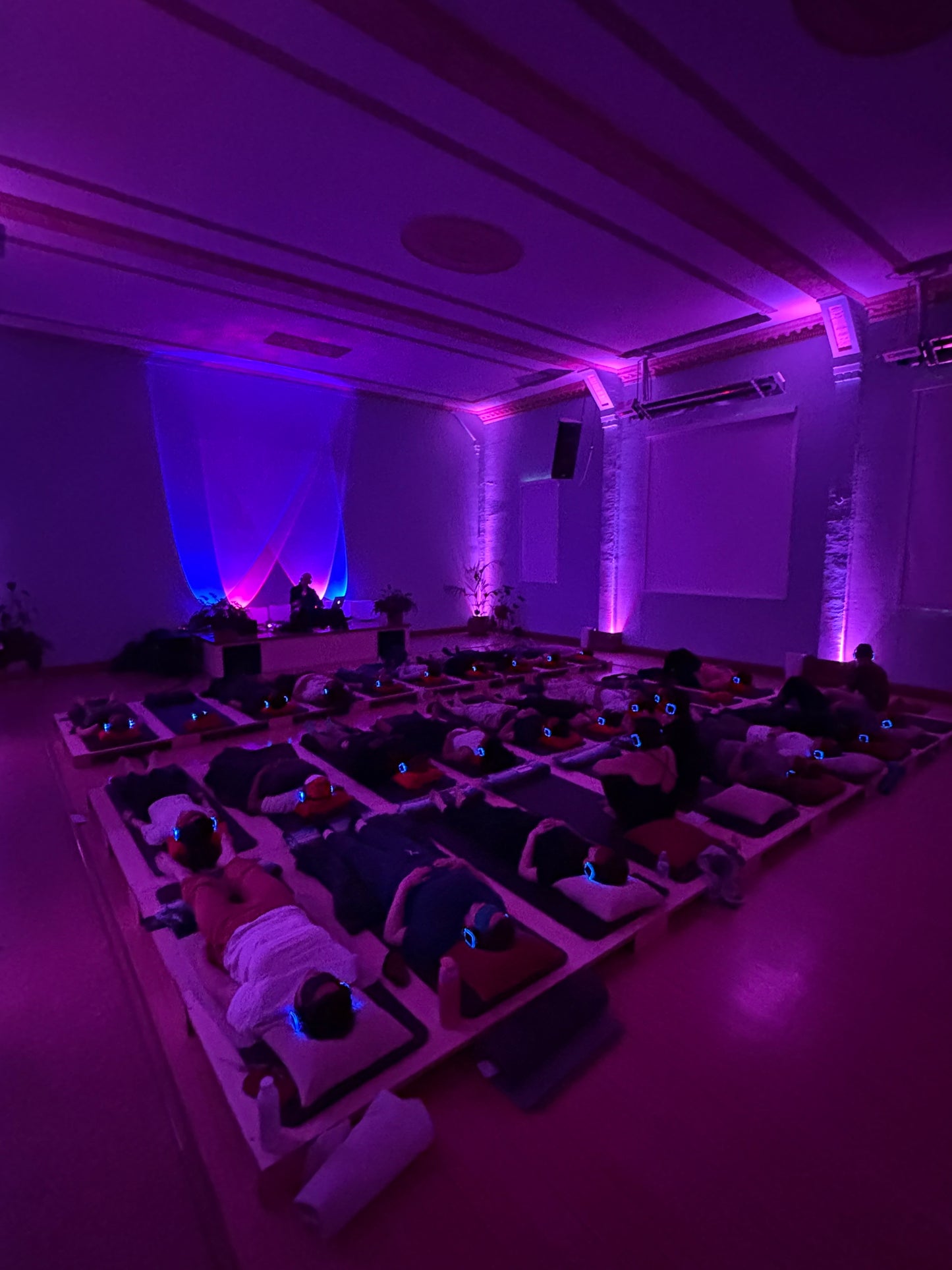 A crown lying down on a large Crescendo Bass Tile installation listening with headphones.