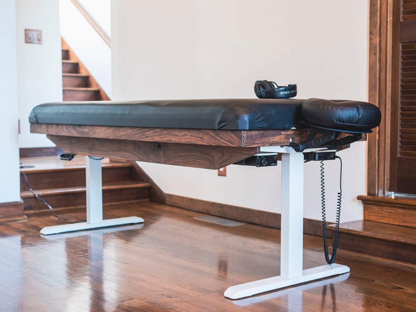 A Crescendo Massage Table placed in a room with a side and partial frontal view.