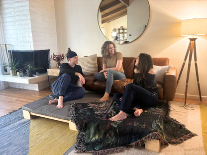 three people socializing in a living room with a Crescendo Bass Bed.